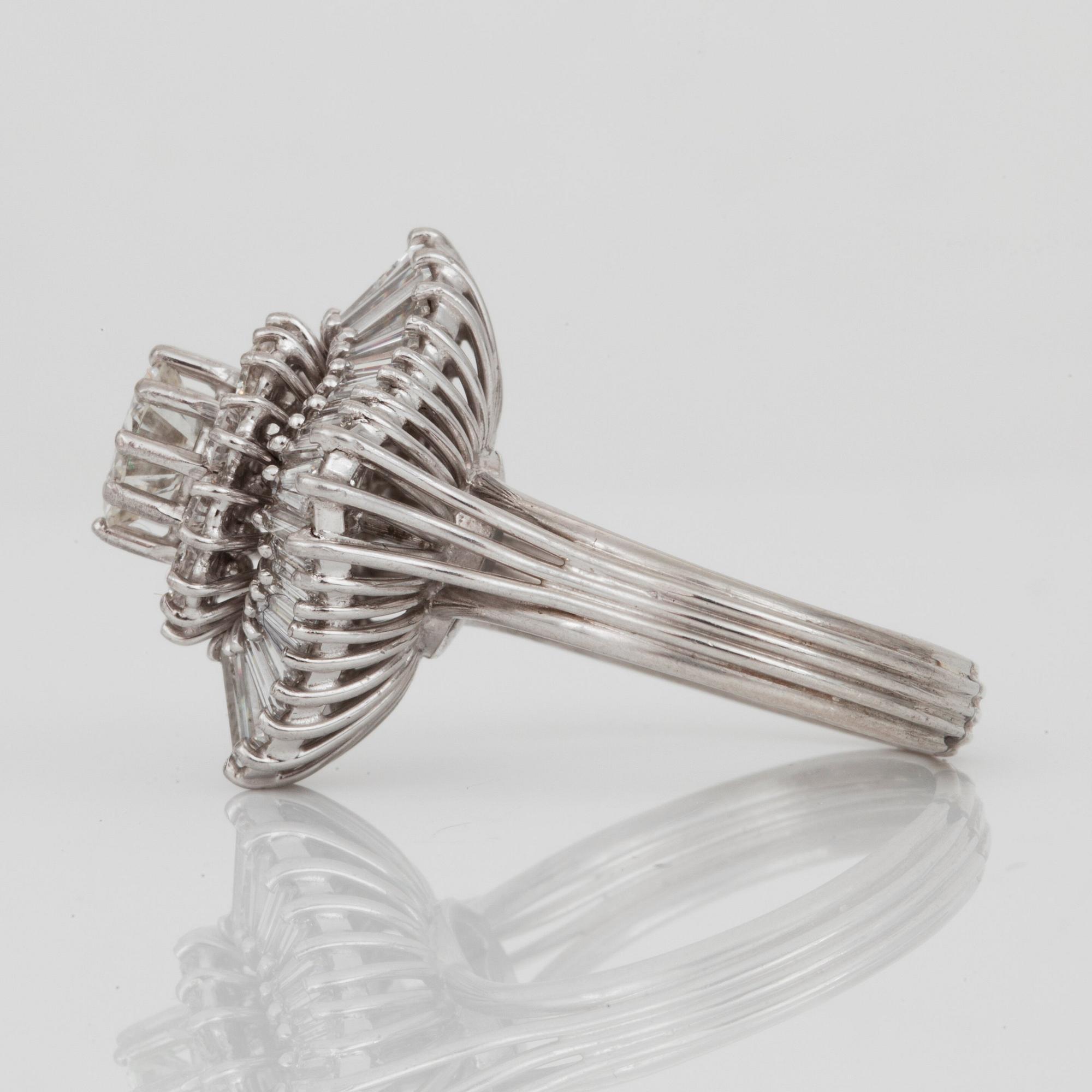 A brilliant- and trapezoid-cut diamond ring. Center diamond circa 1.10 cts and surrounding diamonds circa 1.00 ct.