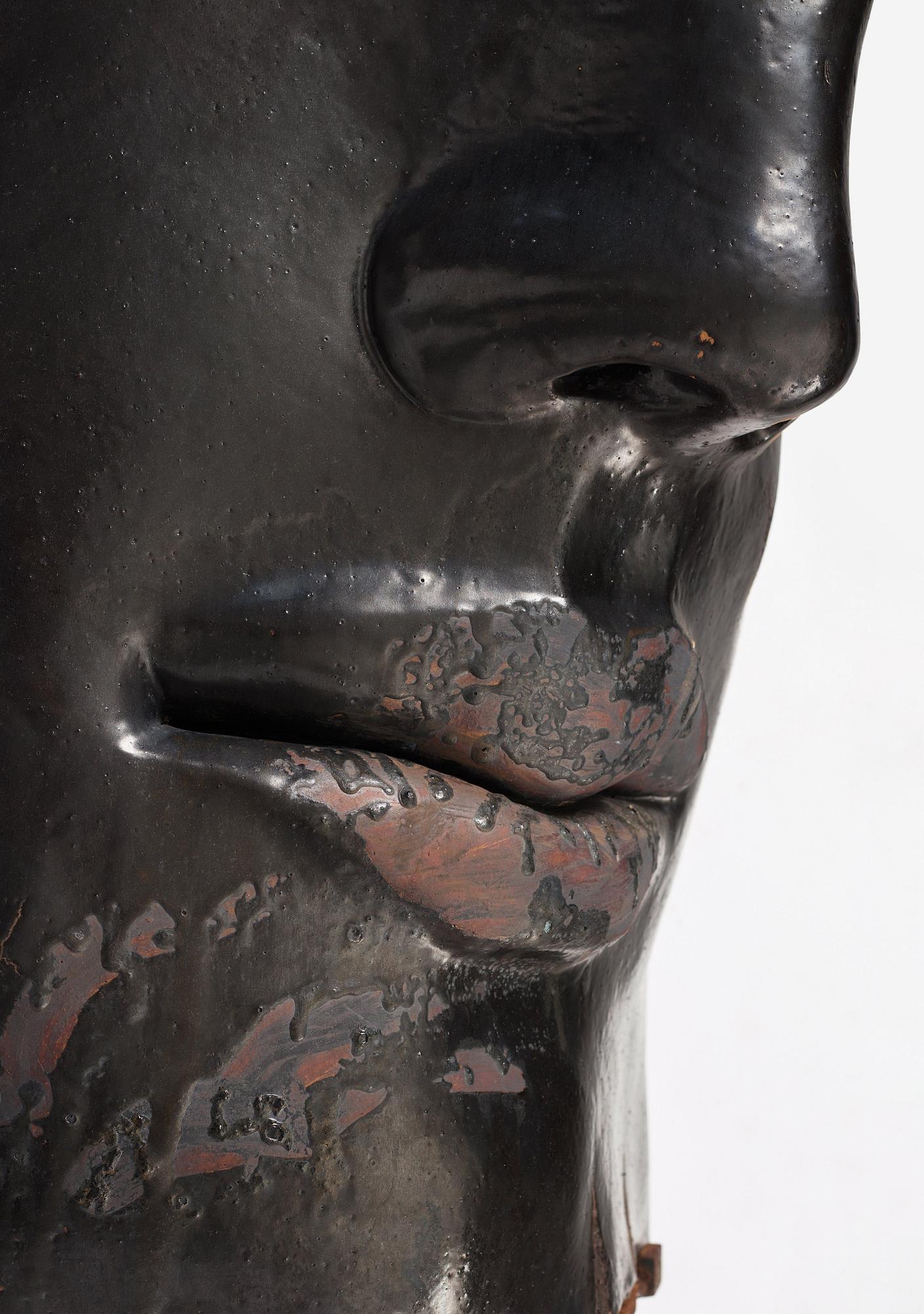 Hertha Hillfon, a black glazed stoneware wall sculpture in two parts of a face and a sky, executed in her own studio, Stockholm 1960s.