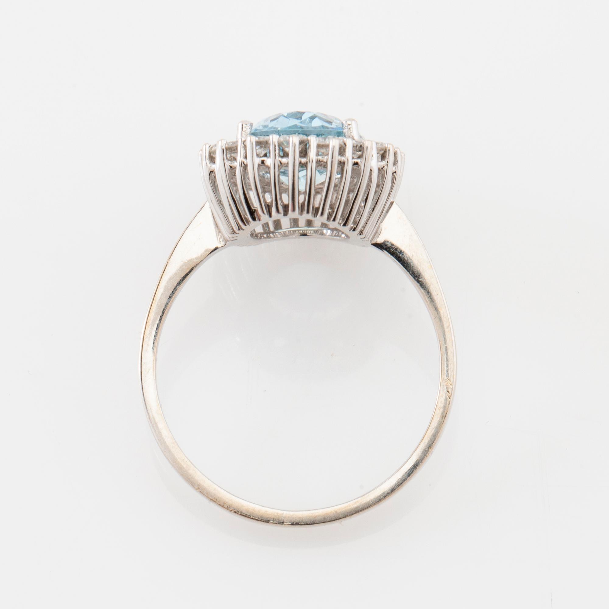 Ring 18K white gold set with an oval faceted aquamarine and round brilliant-cut diamonds.