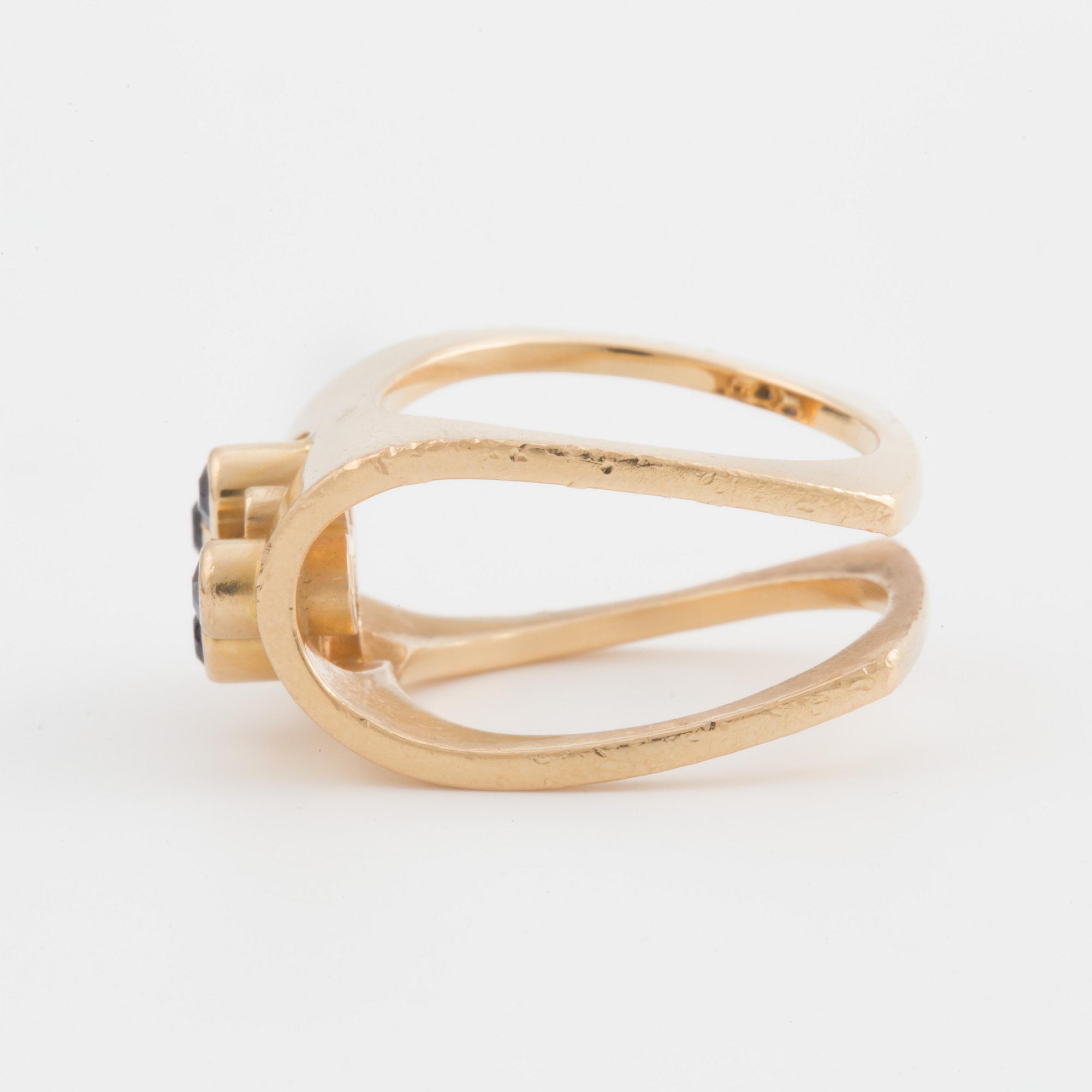 A ring set with four, round, mixed- cut, probably synthetic sapphires.