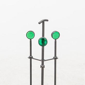 A set of three metal and glass fire place utensils and a candlestick by Gunnar Ander, second half of the 20th century.