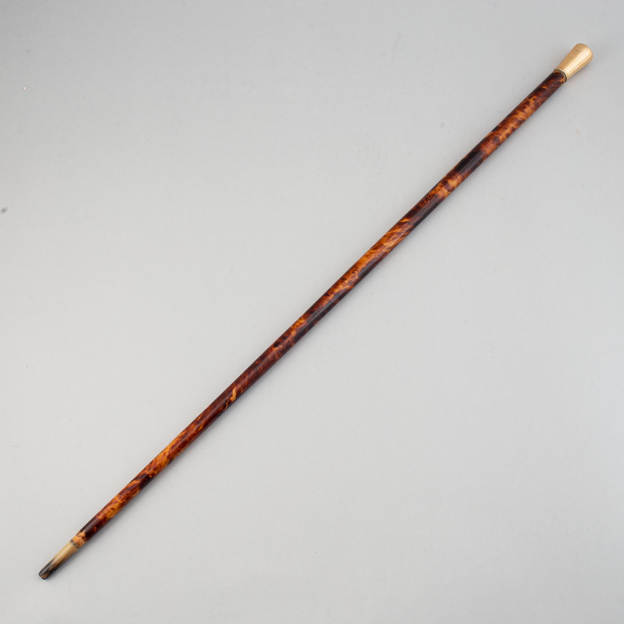 A tortoise imitation veneer, bone, and 14 ct gold walking stick.