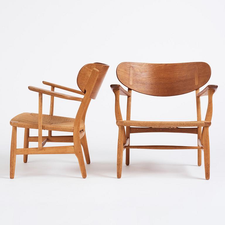 Hans J. Wegner, a pair of "CH 22" oak chairs, Carl Hansen & Son, Odense, Denmark, mid 20th century.