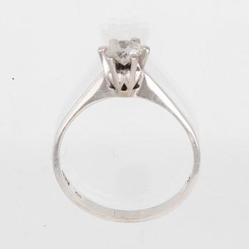 An 18K white gold solitaire ring set with a round brilliant-cut diamond.