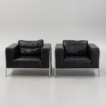 A pair of leather upholstered lounge chairs,