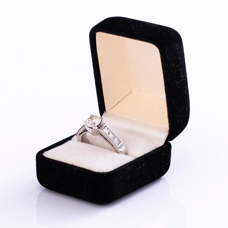 An 18K gold ring with a brilliant-cut diamond ca. 1 ct and princess-cut diamonds ca. 0.7 ct in total.