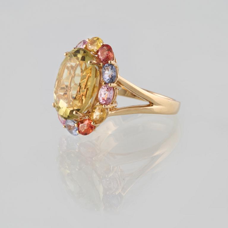 RING, 18K guld med fasettslipad gul topas ca 7.02 ct samt olikfärgade safirer ca 2.95 ct. Vikt 6,6 gram.