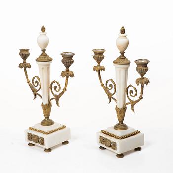 A Louis XVI-style mantle clock and a pair of candelabras. Early 20th century.