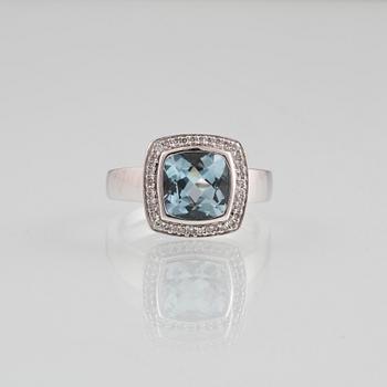 RING, 18K vitguld med fasettslipad blå topas samt 36 briljantslipade diamanter, ca 0.18 ct. Vikt 8,2 gram.