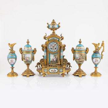 A French mantel clock, two urns and two depicters, second half of the 19th Century.