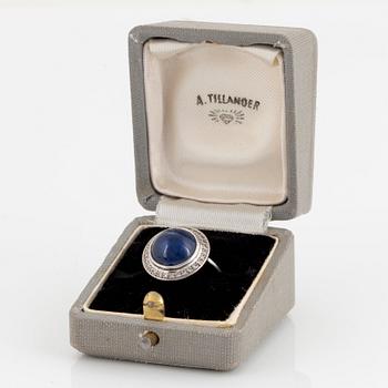 An A Tillander ring in 18K white gold set with a cabochon-cut sapphire and eight-cut diamonds.