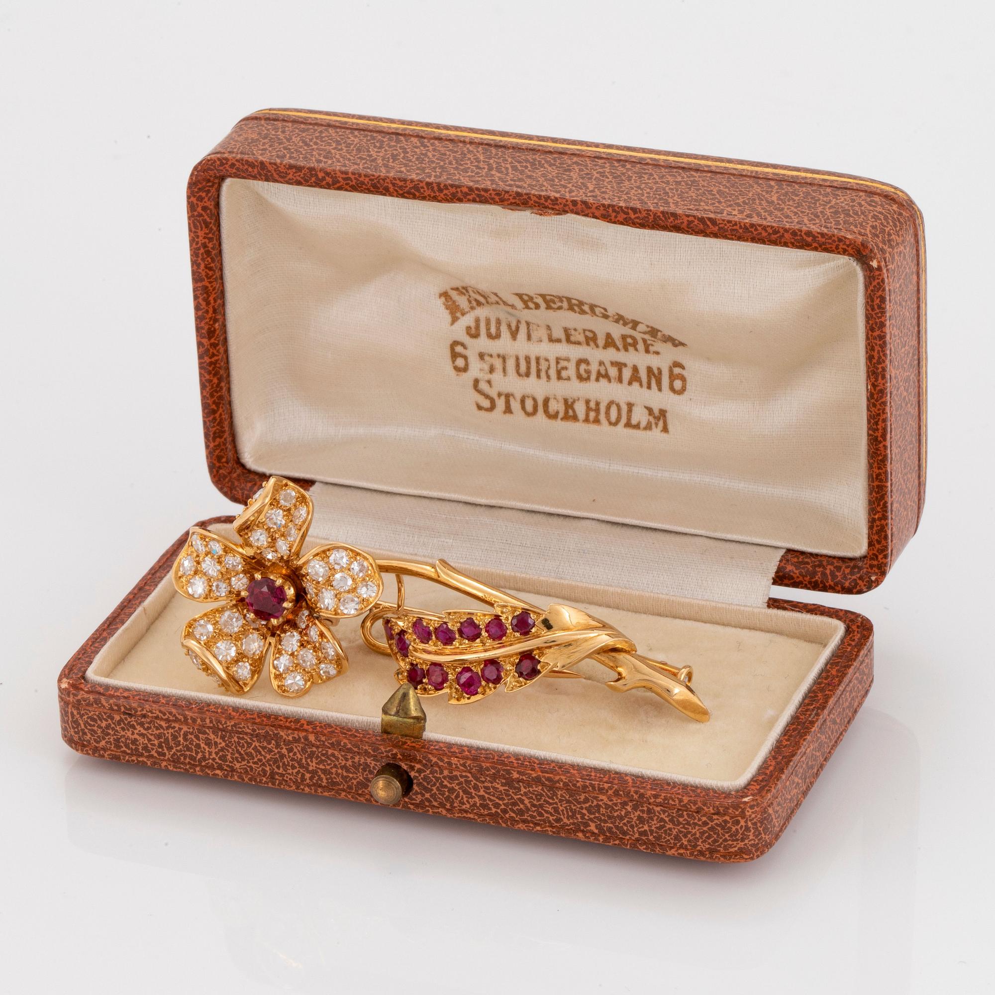 An 18K gold brooch set with faceted rubies and eight-cut diamonds.