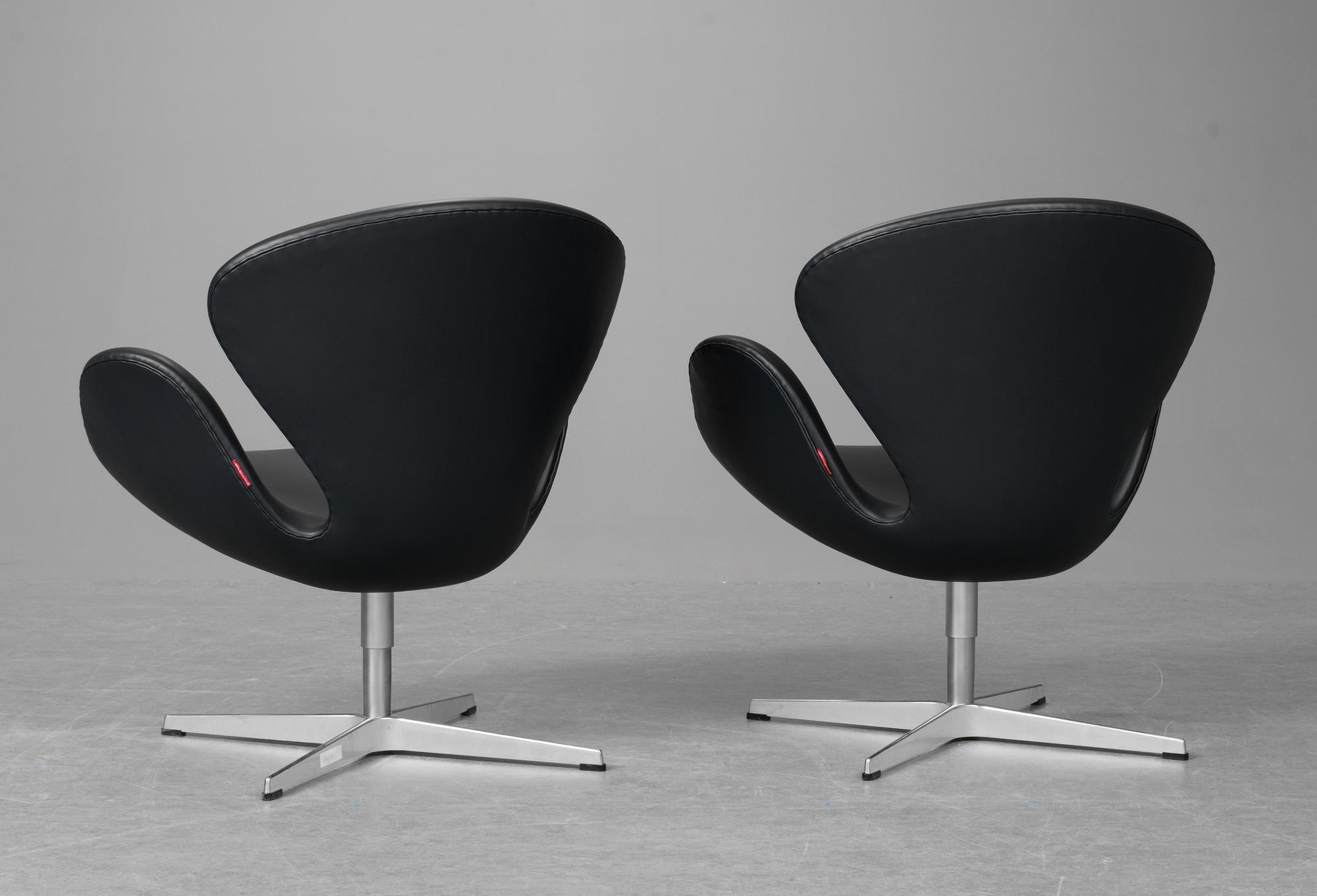 A pair of Arne Jacobsen dark grey leather "Swan Easy Chairs, Fritz Hansen, Denmark 2008.