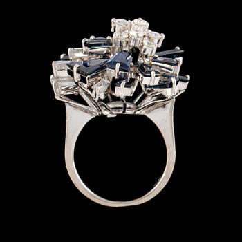 RING, 18K vitguld med 16 trapetsslipade blå safirer samt 5 trapets och 10 briljantslipade diamanter. Vikt 9,4 g.