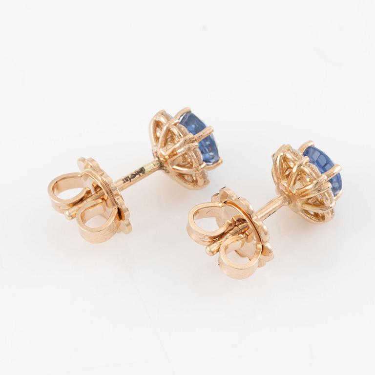 A pair of 14K gold earrings with faceted sapphires and round brilliant-cut diamonds.