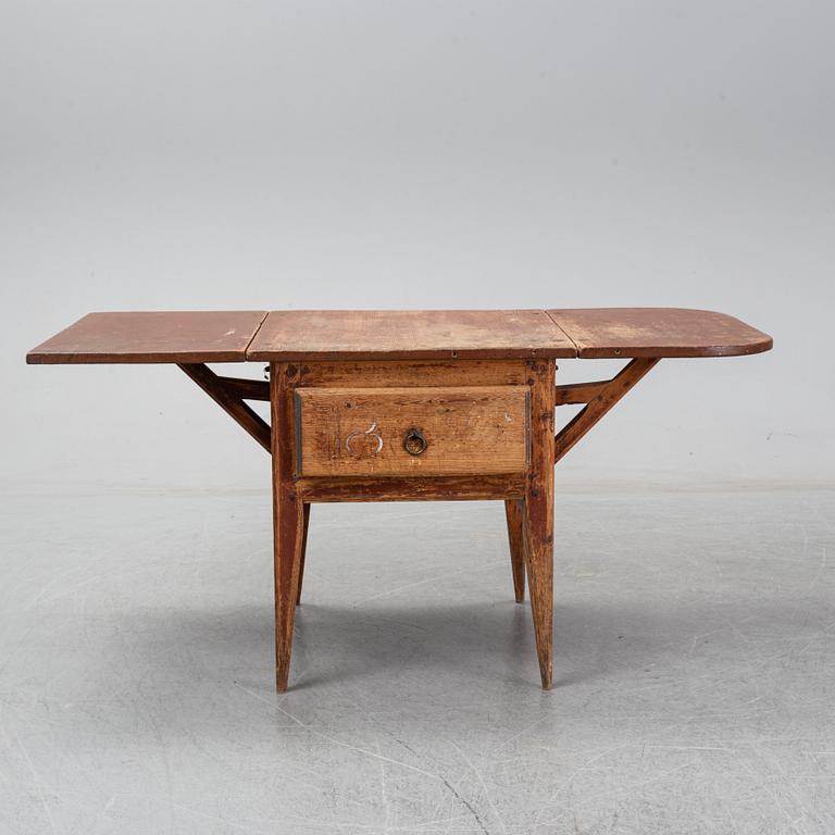 A 19th Century table with drop leaves.