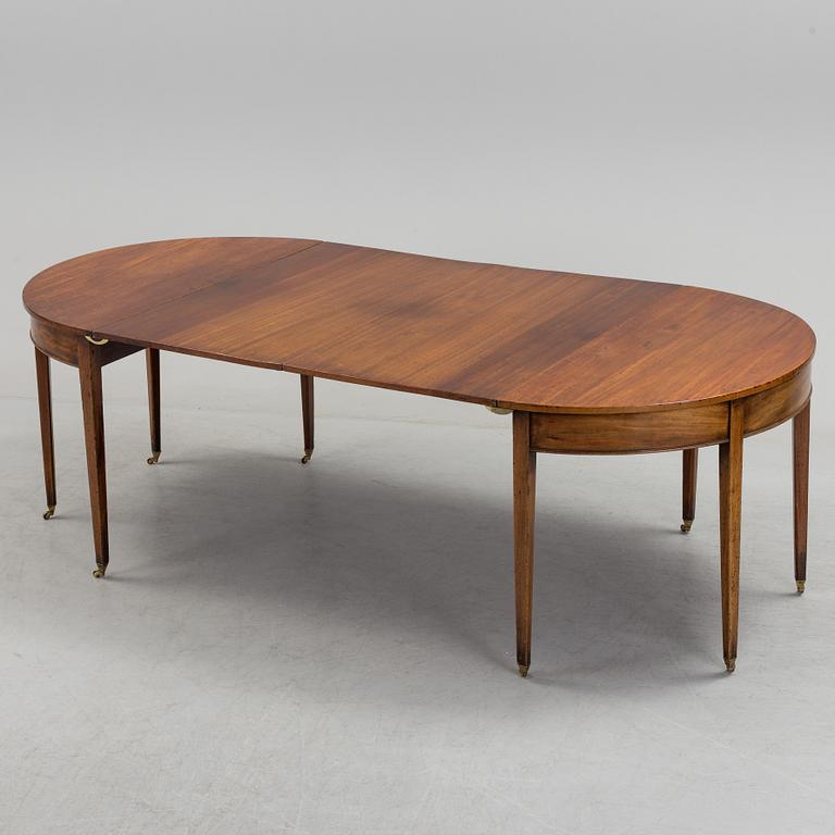 A English George III dining table veneerde with mahogany with two extension leafs from the late 18th century.