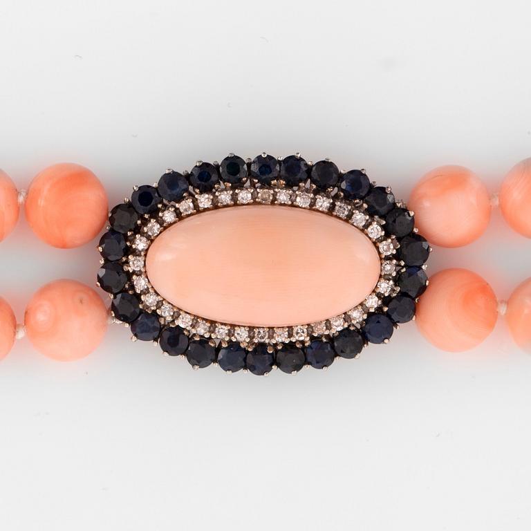 A coral necklace. Clasp with coral, sapphire and diamonds.