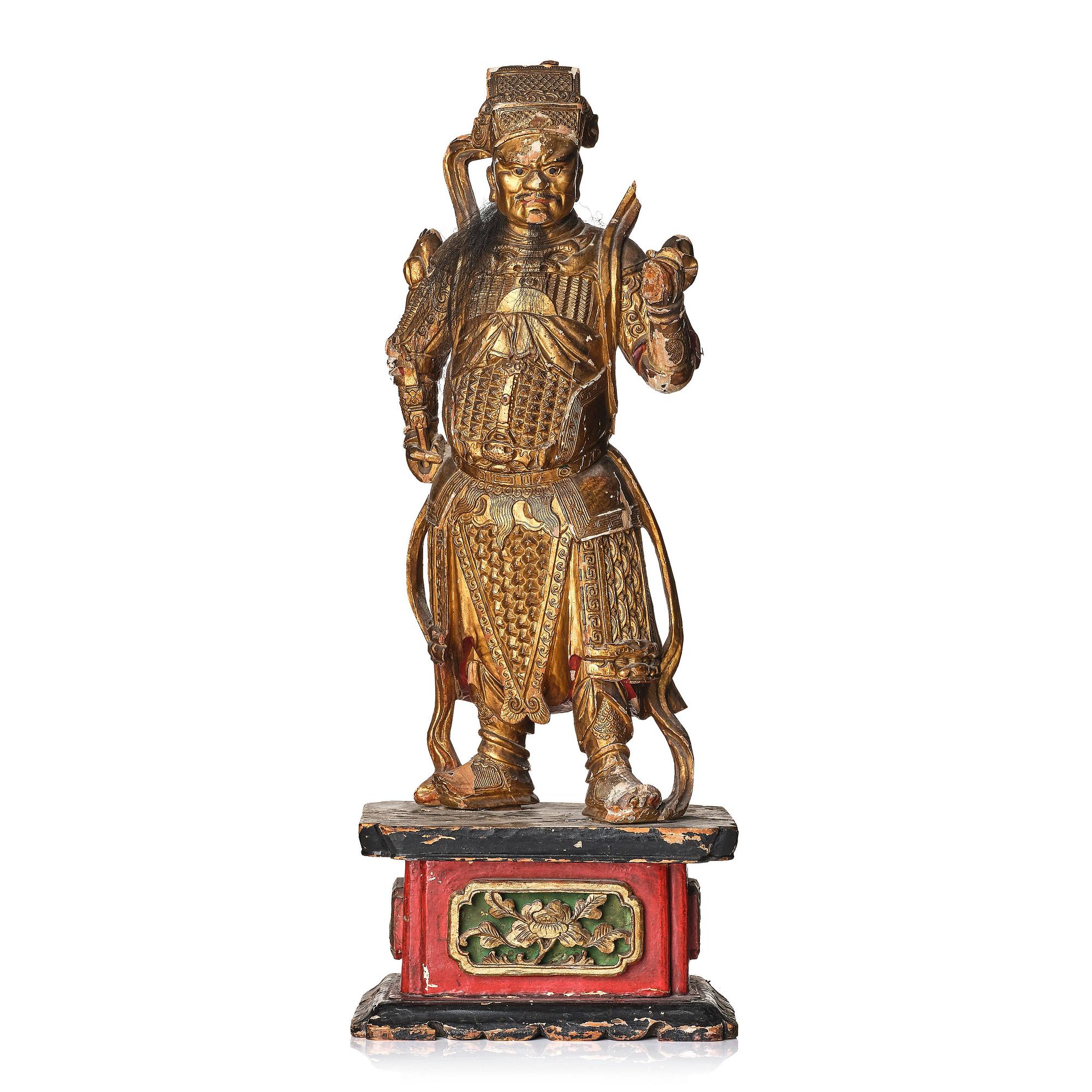 A gilt and lacquered standing figure of a guardsman, Qing dynasty.