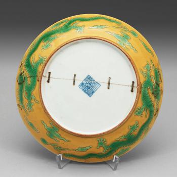 A yellow glazed dish with green five clawed dragons, Qing dynasty, Jiaqings seal mark in underglaze blue (1644-1912).