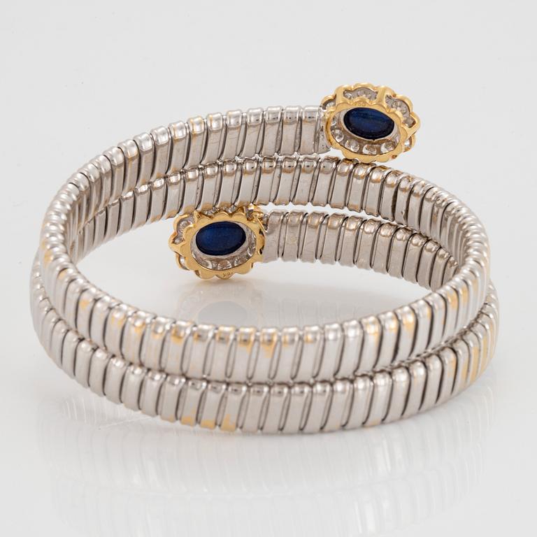 An 18K gold bangle set with cabochon-cut sapphires and round brilliant-cut diamonds.