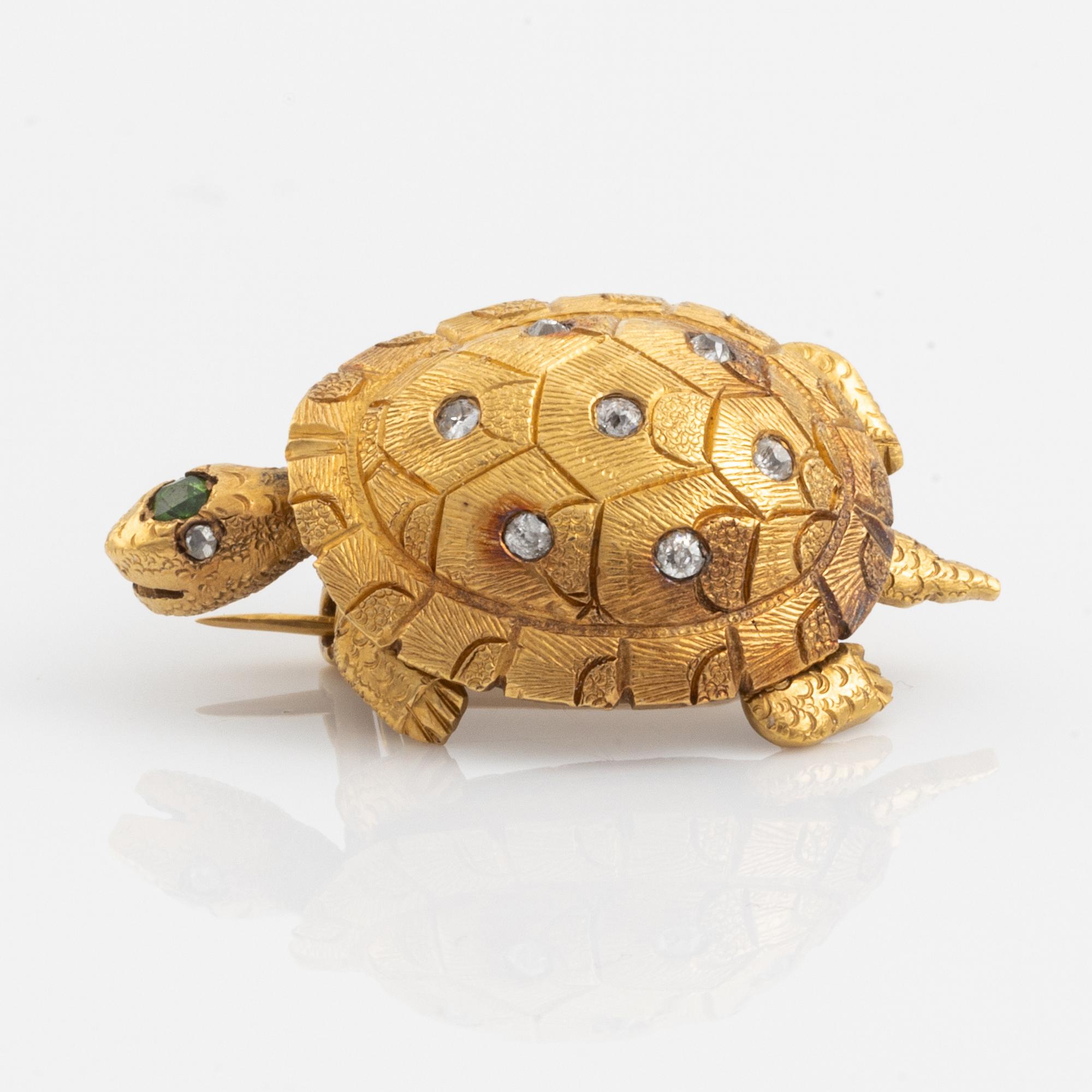 A brooch in the shape of a turtle.