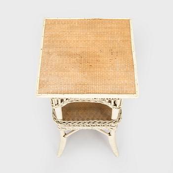 A mid-20th-century three-piece rattan furniture set including two armchairs, and a table.