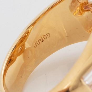 An 18K gold Junod ring set with a facted sapphire and tapered baguette-cut diamonds.