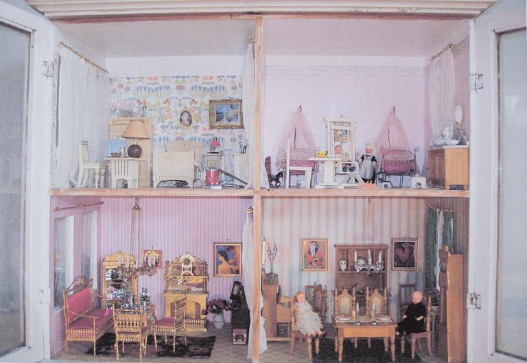 A doll house with interior and dolls ca 1910.