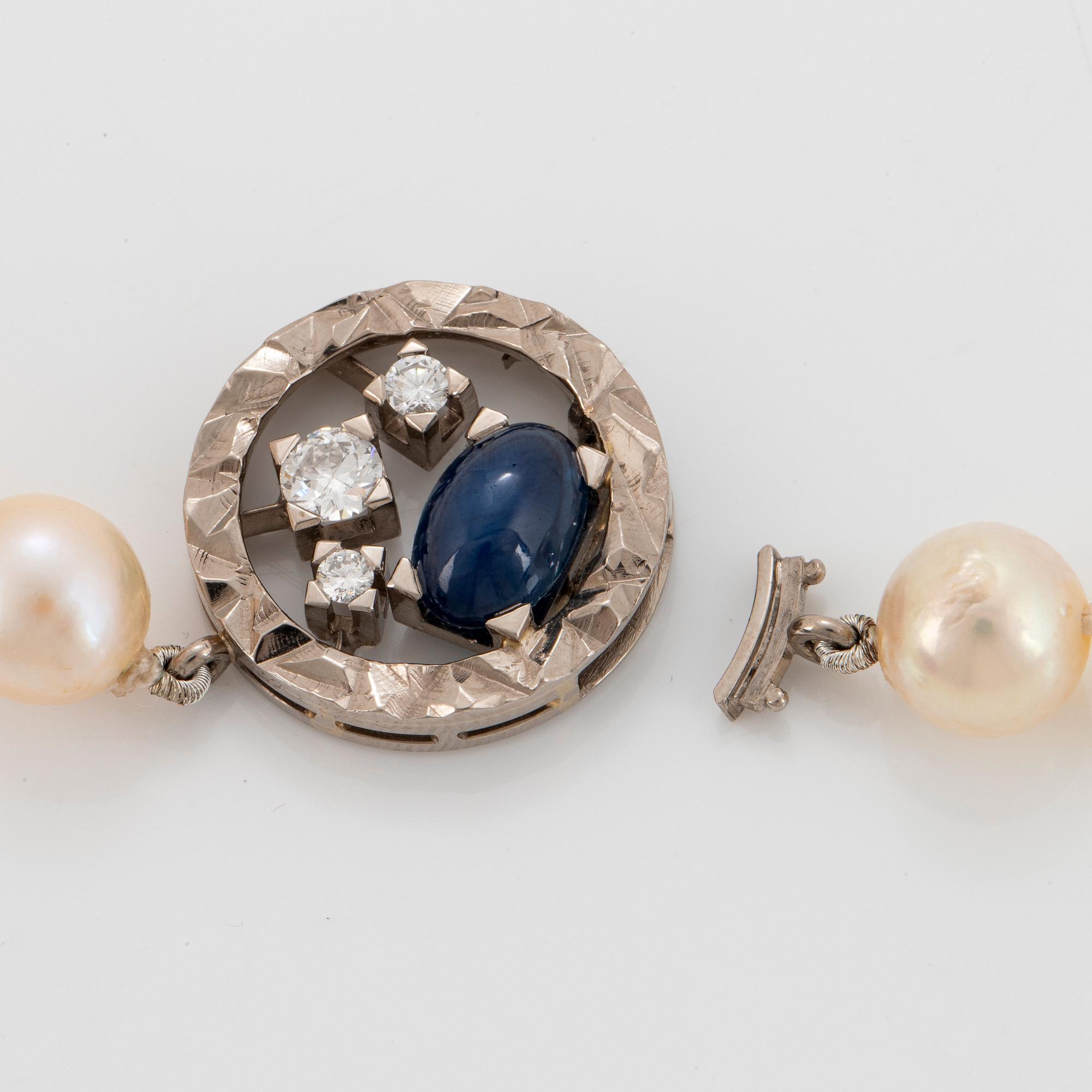 A Rey Urban cultured pearl necklace with an 18K white gold clasp set with a cabochon-cut sapphire.