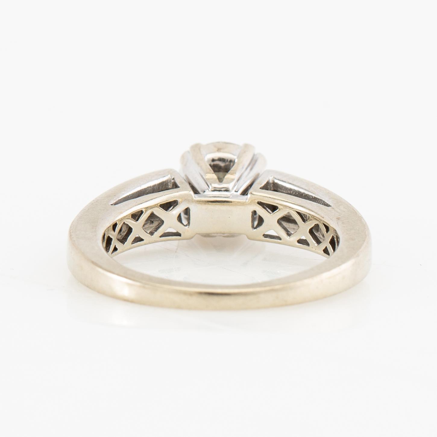 Ring 14K white gold set with a round brilliant-cut diamond, as well as princess-cut and baguette-cut diamonds.