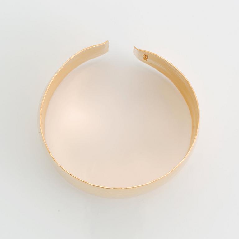 An 18K gold bangle.