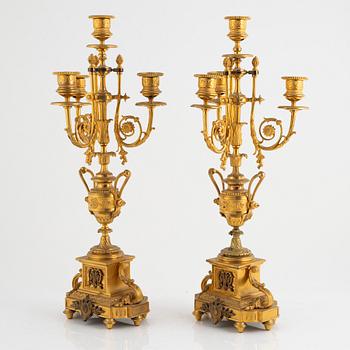 A table clock and a pair of candelabras, Louis XVI-style, France, beginning of the 20th century.