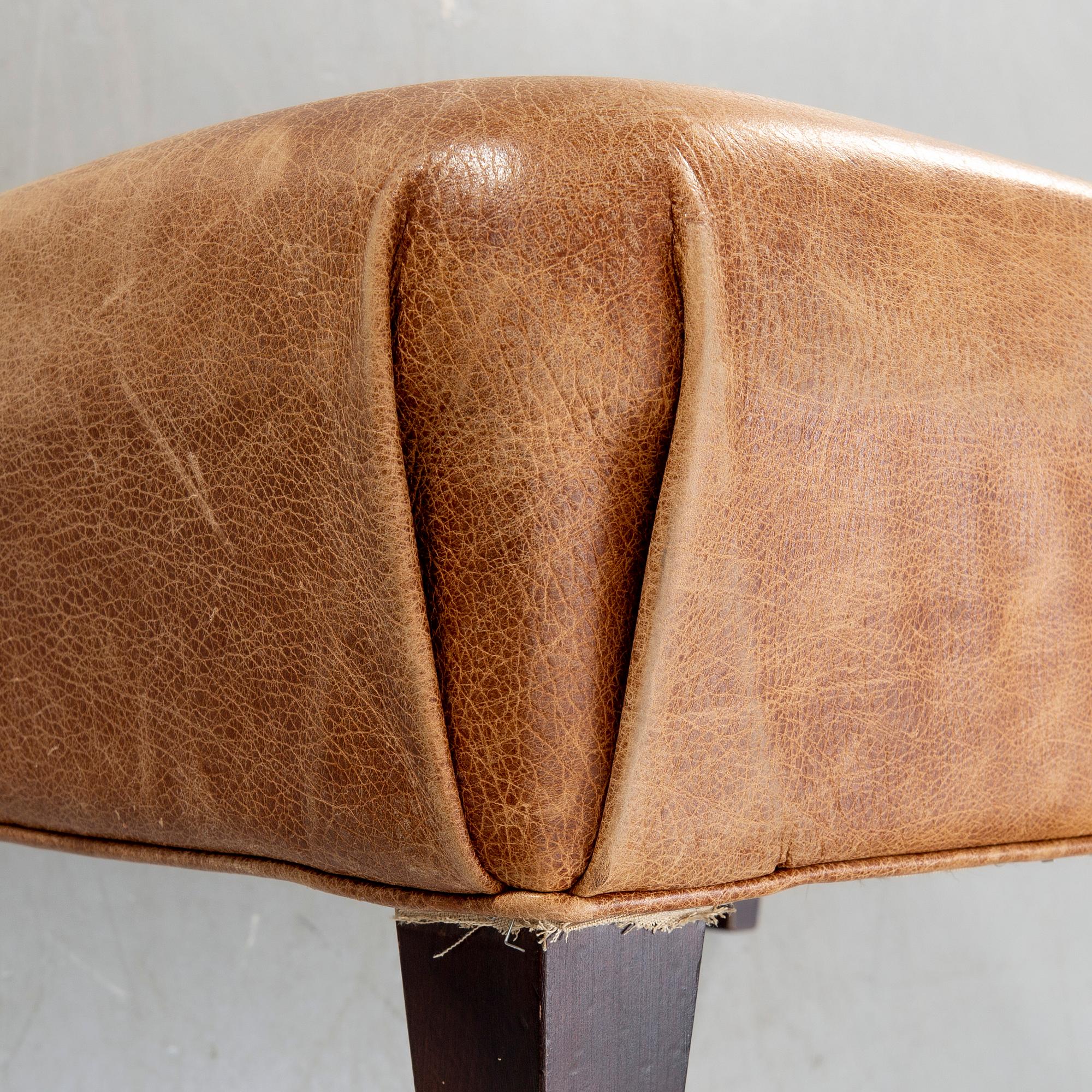 A leather ottoman/coffee table alter part of the 20th century.