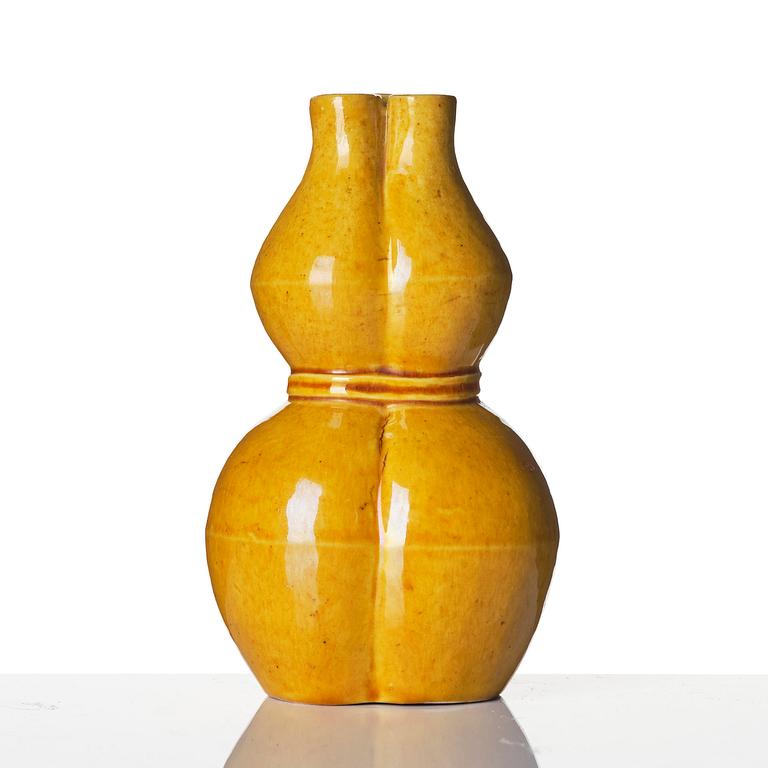 A yellow glazed triple spouted double gourd vase, Qing dynasty, 18th century.
