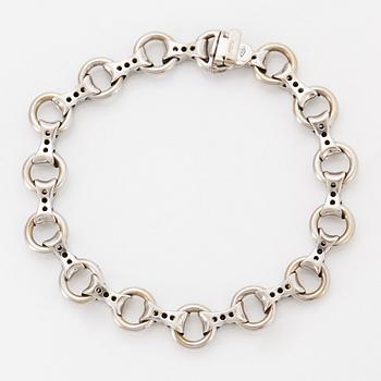 An 18K white gold bracelet set with round brilliant-cut diamonds.