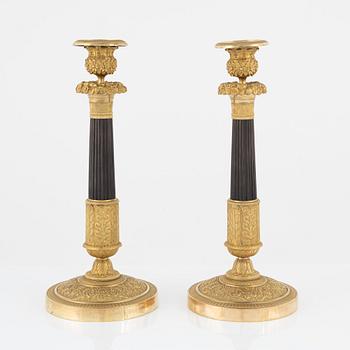 A pair of French Empire ormolu and patinated bronze candlesticks, early 19th century.