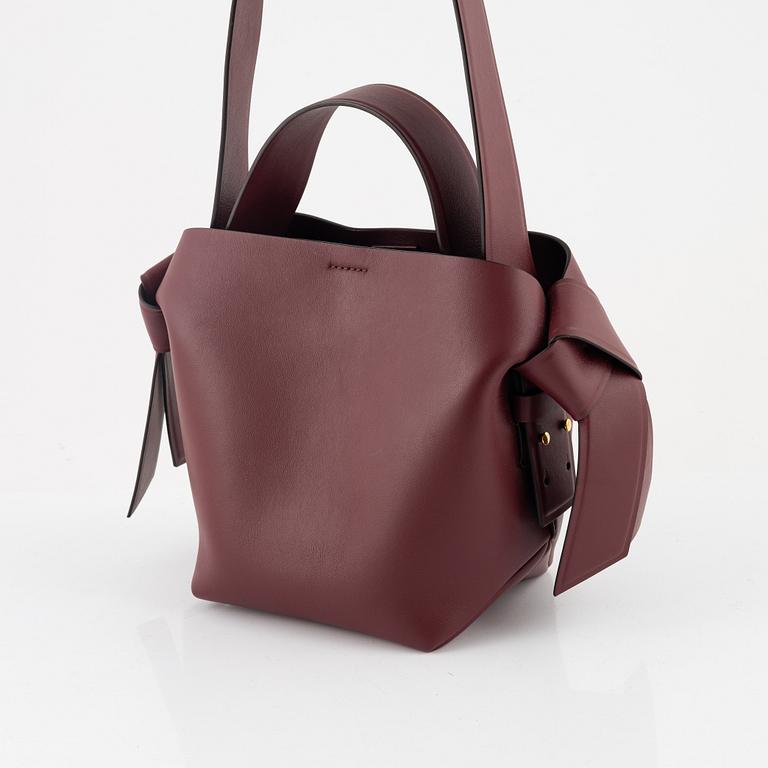 Acne Studios, a burgungy leather 'Musubi Mini' handbag.