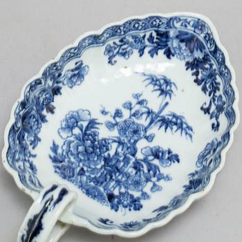 A blue and white saucer with a famille rose Canton candle holder, Qing dynasty, Qianlong and 19th century.