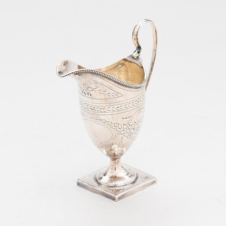 A sterling silver cream jug from London 1796, and a sterling spoon with maker's mark of Thomas Wallis II, London 1805.