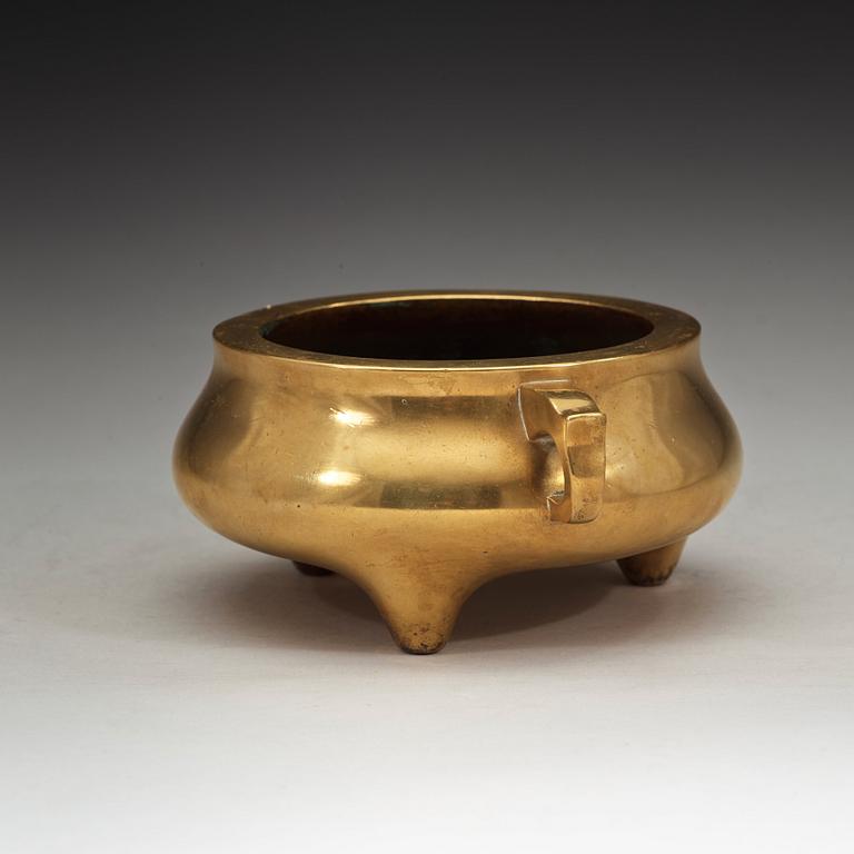 A polished bronze tripod censer, Ming dynasty (1368-1644).