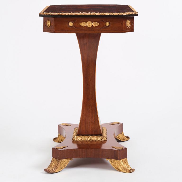 A north european Empire  'Umdruck'-decorated mahogny and gilded metal table.