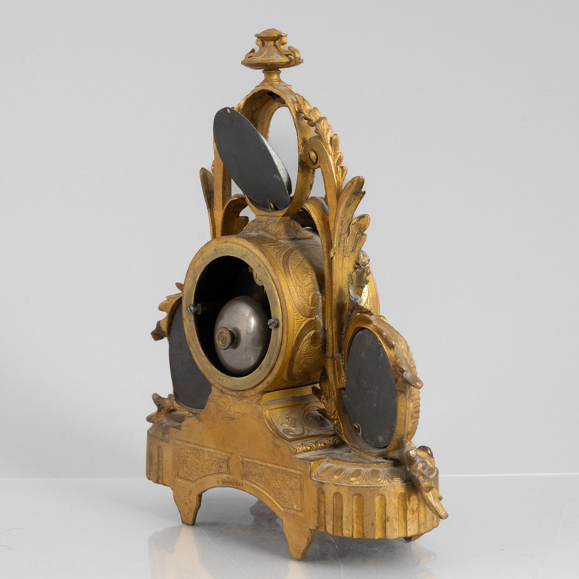 A Louis XVI style mantel clock and a pair of candelabra, circa 1900.