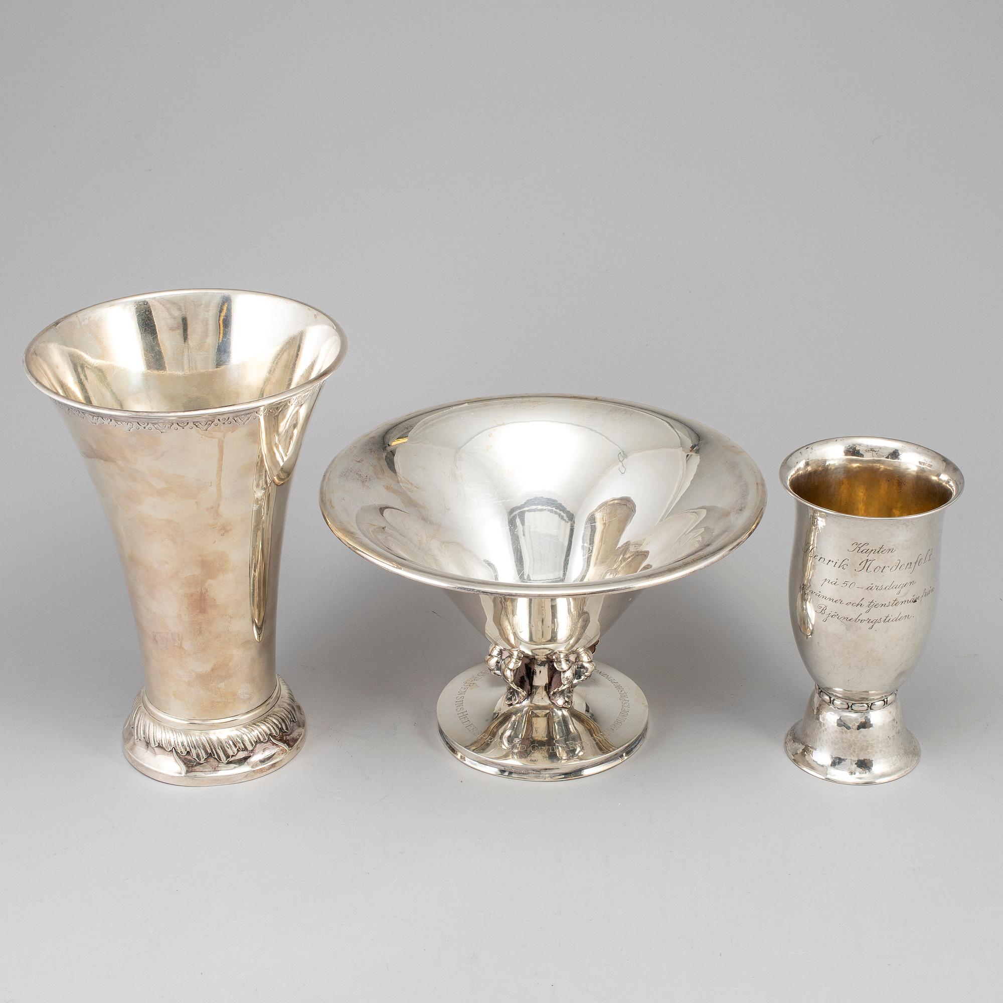 Two silver beakers and a bowl.