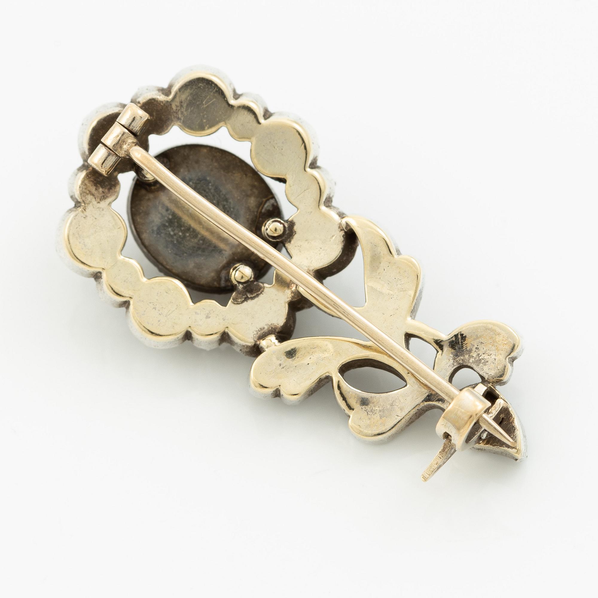 Brooch in silver set with rose-cut diamonds in the shape of a flower.