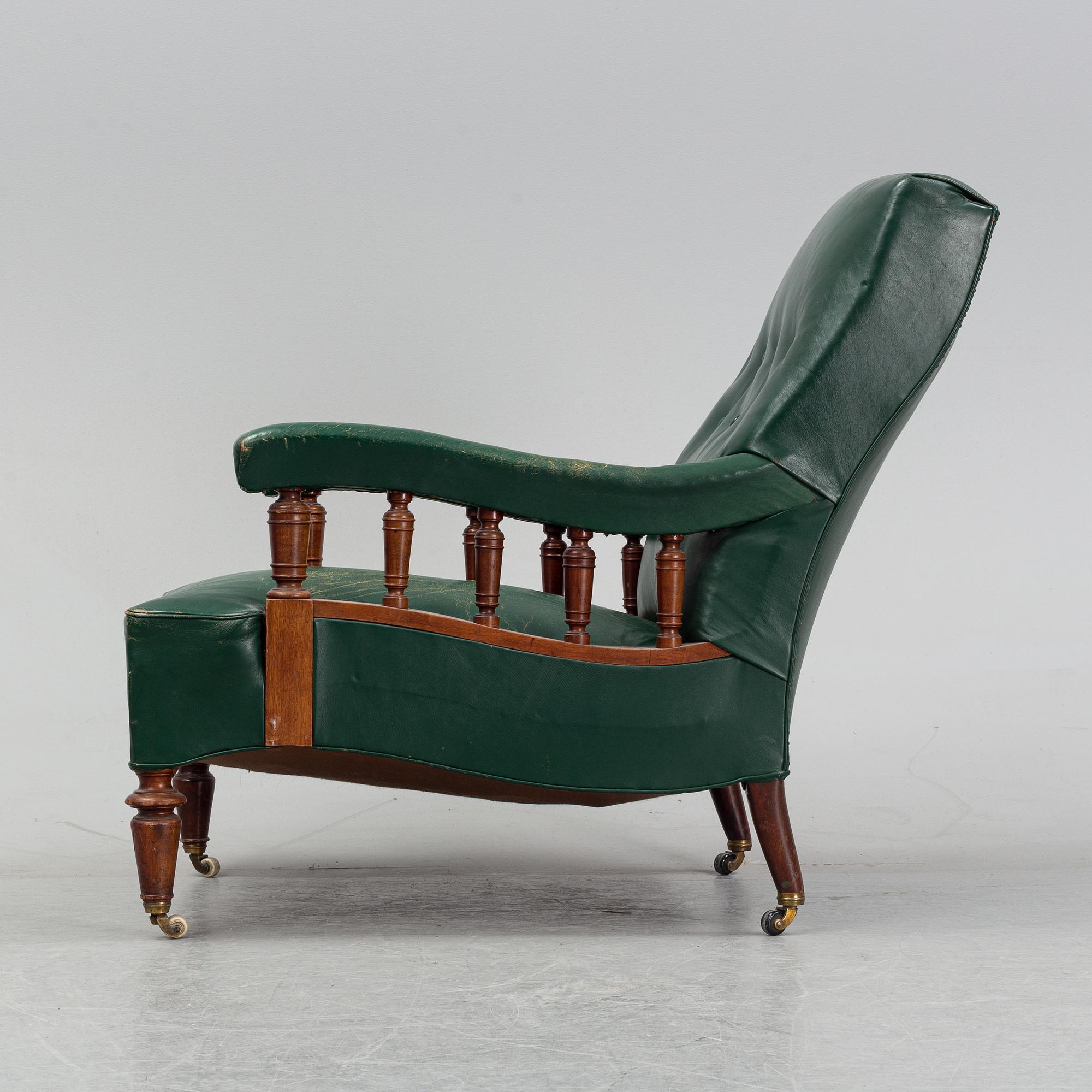 An early 20th Century easy chair with leather upholstery.