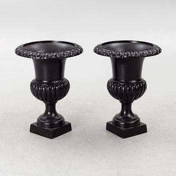 A pair of cast iron garden urns, 20th century.