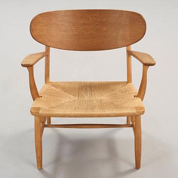 A Hans J Wegner 'CH-22' oak easy chair, Carl Hansen & Son, Odense, Denmark.