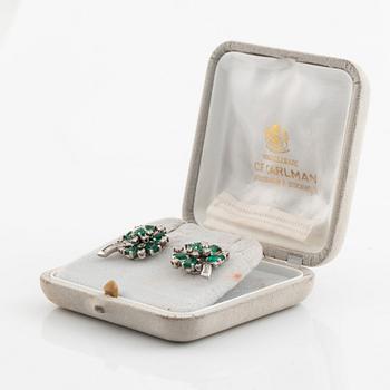 White gold, emerald and round brilliant- and baguette cut diamond ear clips.