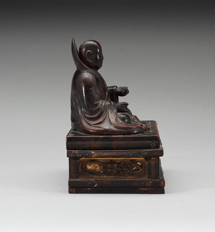 A lacquered wooden Japanese deity on a stand, 19th Century.